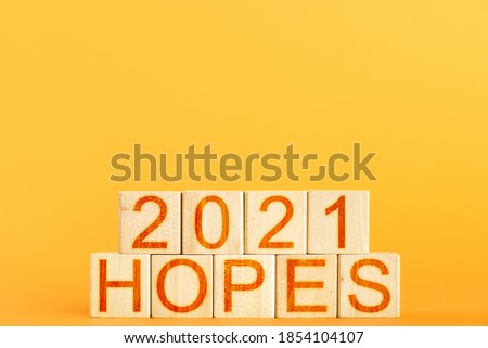 2021 hopes. wooden cubes with the inscription 2021 hopes on an orange background