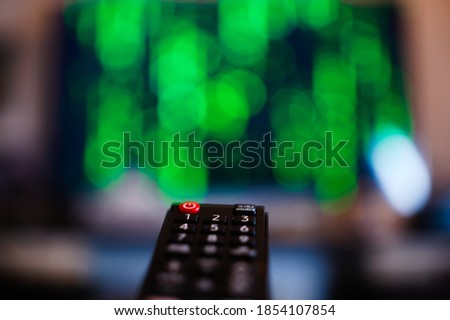 TV remote control on the background of the screen with a matrix code
