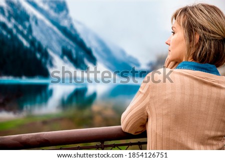 Beautiful Woman enjoying the snowy Mountain lake view. Copy space