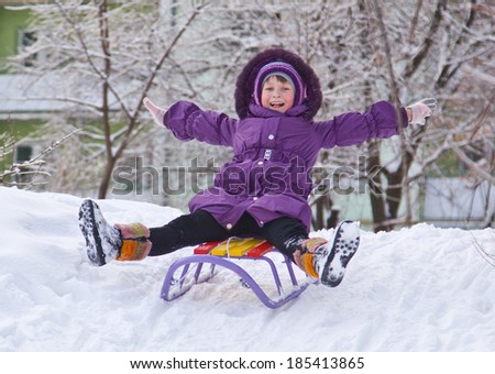 happy girl riding a sleigh