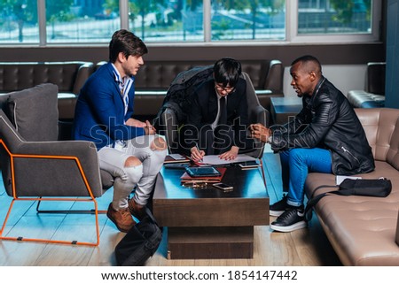 Three multi-ethnic businesspeople having a meeting in a modern office.