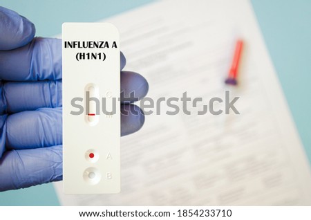 Doctor shows a test for influenza H1N1 and COVID-19 2019-nCoV viral diseases. Laboratory test has tested positive. Doctor is holding a rapid laboratory test for COVID-19. Sars-cov-2 and H1N1 virus. Royalty-Free Stock Photo #1854233710