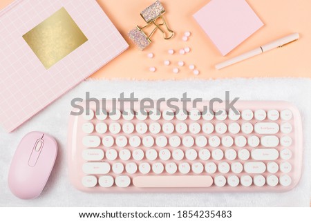 flat lay pink stationery on work desk in orange pastel background	