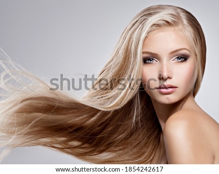 Face of the Beautiful young woman with long straight  hair - posing at studio over gray background Royalty-Free Stock Photo #1854242617