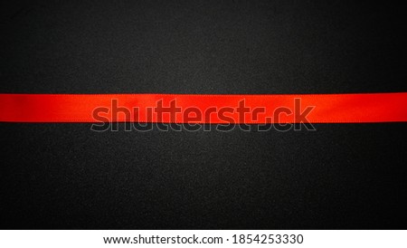 Red satin ribbon on black background