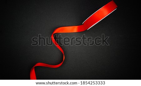 Red satin ribbon on black background