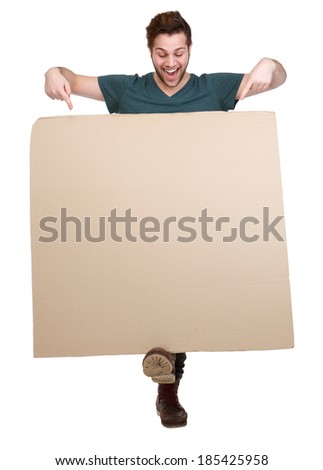 Full length portrait of a smiling man pointing fingers down to blank poster board on isolated white background