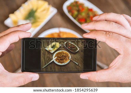 Food photography on smartphone.Mans hands make phone photography of l traditional meals. lunch or dinner.Beef stroganoff. For social media, blogging.  Top view mobile phone.