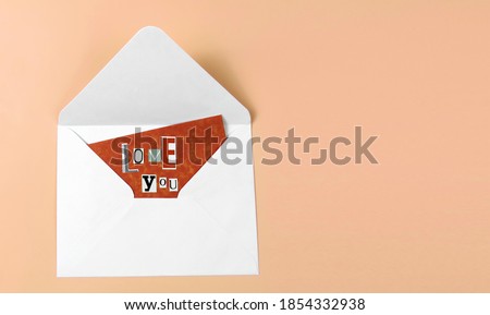  love you words made of paper letters, red paper, white envelope, pastel pink background. copy space. Romantic card  heart. Creative laconic art design, wallpaper. Valentine's Day symbol, abstraction 