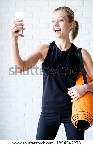 Young smiling fitness woman doing selfie after workout