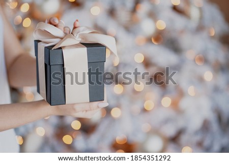 holiday box black decorations Golden balls garland of Golden color, white Christmas tree with snow. Beautiful decorations for the holiday of a happy new year. space for copying.