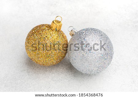 Christmas ornaments of gold and silver balls with blurred textured background