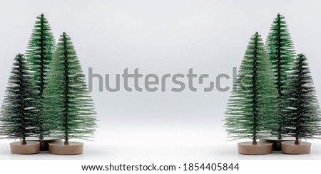 Panoramic background, Season greeting theme with selective focus of mini artificial Christmas tree on white screen, Free copy space, Can be used as backdrop, Graphic design, Banner or website concept.