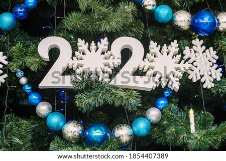 Christmas tree with big Christmas balls, garland and sign 2021.