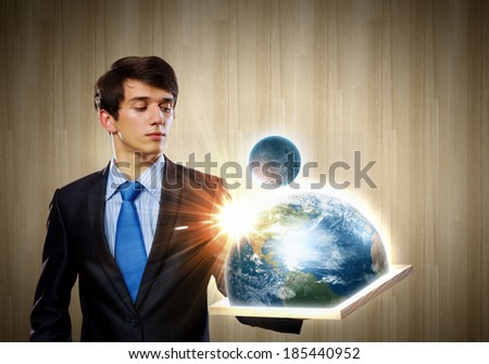 Handsome businessman holding frame with Earth planet. Elements of this image are furnished by NASA