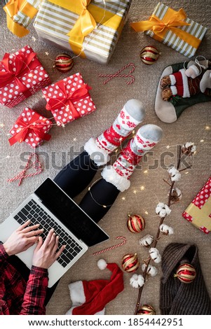 Top view of woman shopping online at christmas holidays holding a present. Christmas online shopping