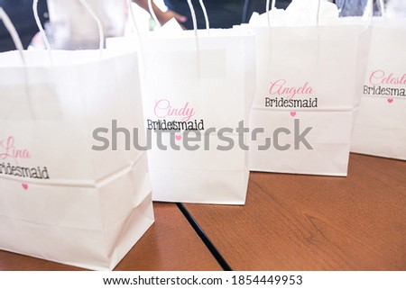 white gift bags with names of bridesmaids on them