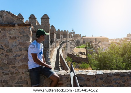 Selective focus of a boy on top of the wall of the fortress of Avila in Spain on a summer day