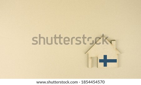 Putting cardboard house icon with national flag of Finland. Real estate market concept