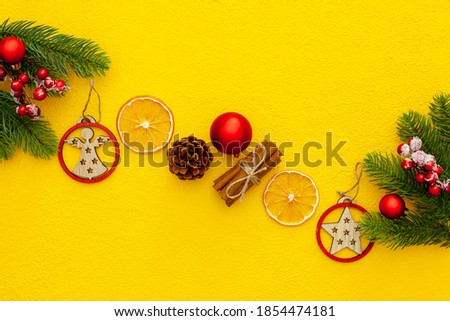 Spruce branch, cones and vintage toys decoration on christmas or new year on yellow background