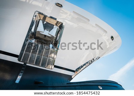 Closeup detail of the bow of a new  white modern superyacht on dry dock, with a bulbous bow on a sunny day. With stainless steel  anchor. Royalty-Free Stock Photo #1854475432