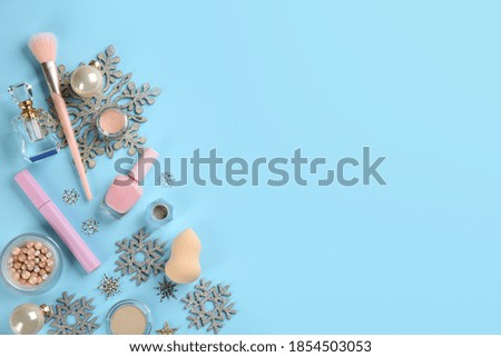 Flat lay composition with decorative cosmetic products on light blue background, space for text. Winter care