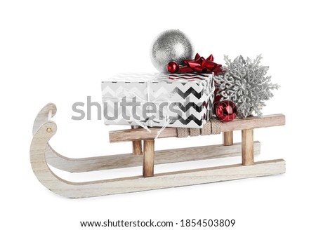 Wooden sleigh with gift box and Christmas decorations isolated on white