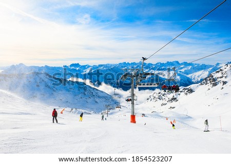Ski resort in winter Alps. Skiers ride down the slope. Val Thorens, 3 Valleys, France. Beautiful mountains and the blue sky, winter landscape