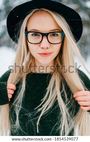 Portrait of pretty stylish blonde girl in hat and glasses