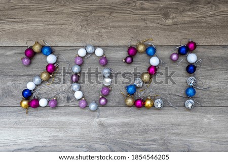 The number 2021 from New Year's decorations are laid out on a wooden background