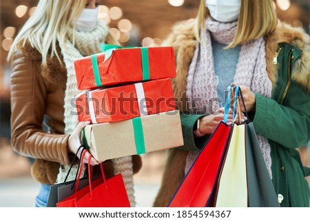 Midsection of two friends shopping together wearing a mask, coronavirus concept