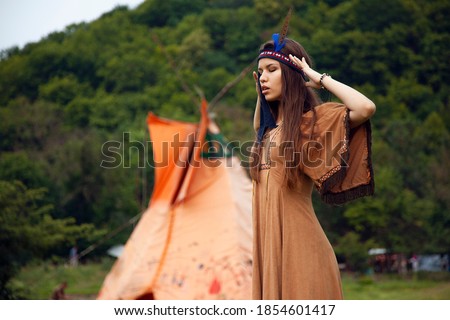 Profile portrait of a beautiful girl. Native american, Indian woman in traditional dress, posing in the wild forest.