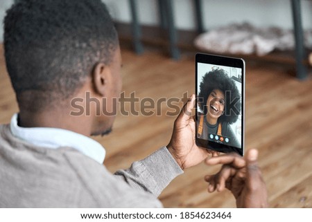 African american man video calling girlfriend on digital tablet. Black couple talking dating by virtual meeting via conference videocall. Remote relationship, online chat concept, over shoulder view. Royalty-Free Stock Photo #1854623464