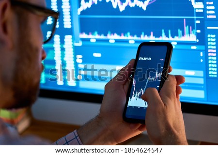 Business man trader investor analyst using mobile phone app analytics for cryptocurrency financial stock market analysis analyze graph trading data index investment growth chart on smartphone screen. Royalty-Free Stock Photo #1854624547