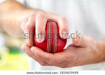 Cricket fast bowler holding ball close up approaching wicket