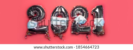 Balloon Bunting for celebration of New Year 2021 made from Silver Number Balloons with protective face masks on pink background. Holiday Party Decoration or postcard concept as New Reality