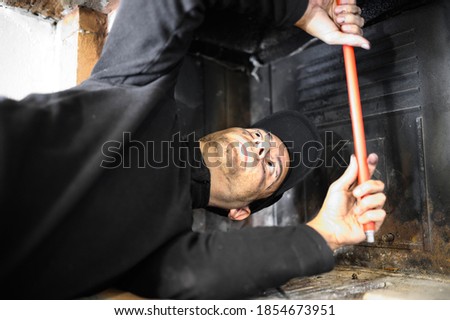 Young chimney sweep at work Royalty-Free Stock Photo #1854673951