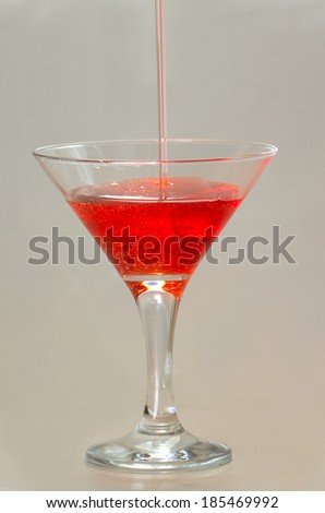 Drop of water falling in martini glass in purple tones