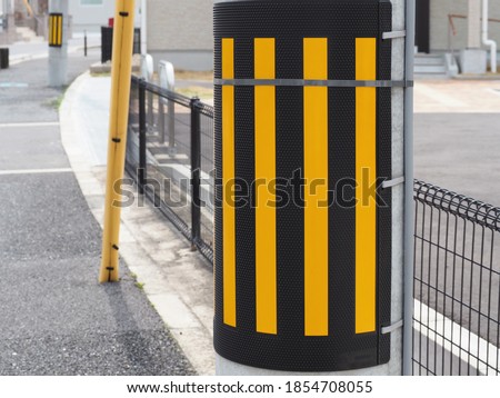 Light reflector attached around the utility pole for traffic safety in a residential area