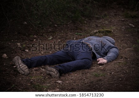 A caucasian man's dead body was found in the park. Murder in the woods. Murdered citizen. Crime scene Royalty-Free Stock Photo #1854713230