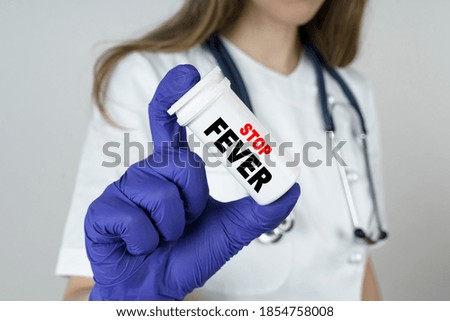 Medicine and health concept. The doctor holds a medicine in his hands, which says - STOP FEVER