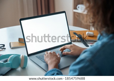 Mockup image of laptop computer with white screen for advertising. Over shoulder close-up view. Writing, typing text. Freelance concept. Online work at home, e learning distance training course.
