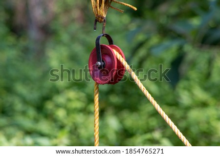 Pulleys are simple machines consisting of a wheel over which a pulled rope runs to change the direction of the pull used for lifting a load or water from well Royalty-Free Stock Photo #1854765271