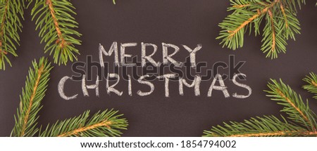 Inscription Merry Christmas and green spruce branches. Decoration for christmas time. Vintage photo