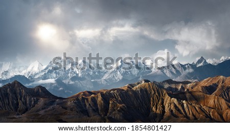 Panoramic view of the scenic landscape of snowy mountains and dramatic clouds.