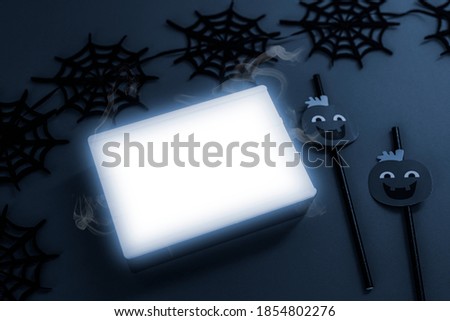 White letter board surrounded by a spider web garland