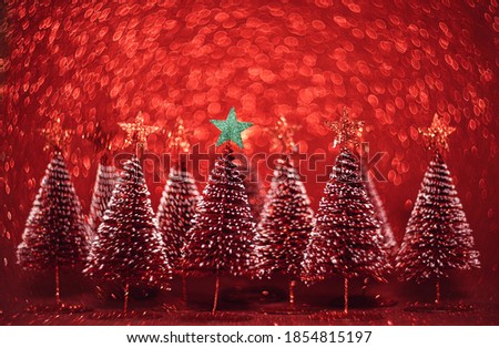 Christmas tree with star on red glitter swirly sparkling lights festive bokeh background.new year holiday greeting card