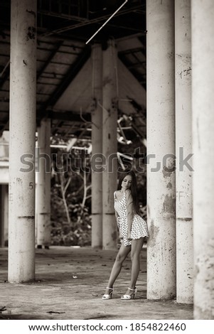 Beautiful girl posing in the abandoned ruined building. Sepia image