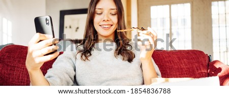 Portrait of handsome woman eating pizza at home and taking selfie photo of herself
