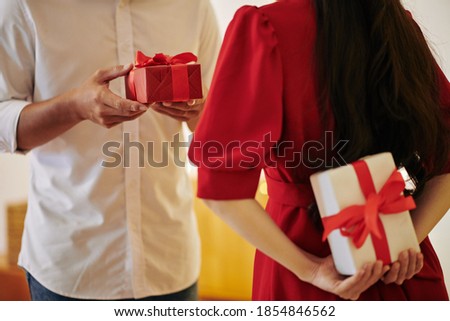Young couple exchanging romantic presents on Christmas eve or Valentines day